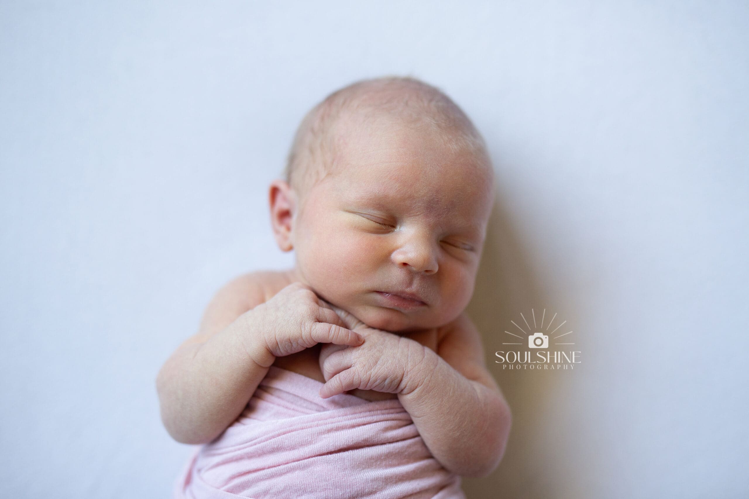This photograph shows a newborn asleep. The image is used to show authentic, natural newborn posing for a photo session.